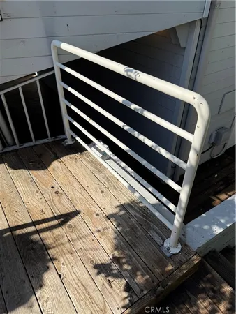 a view of a balcony with wooden floor and fence