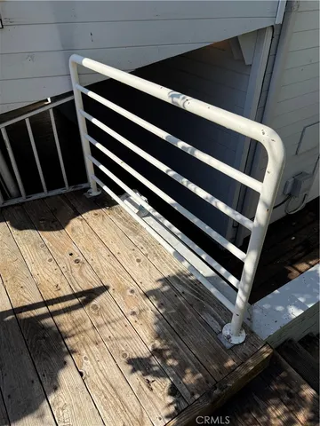 a view of a balcony with wooden floor and fence