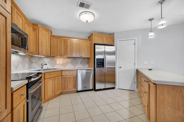 a kitchen with stainless steel appliances granite countertop a refrigerator oven a sink dishwasher and white cabinets with wooden floor