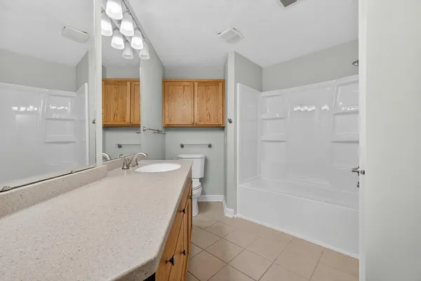 a bathroom with a tub sink and mirror