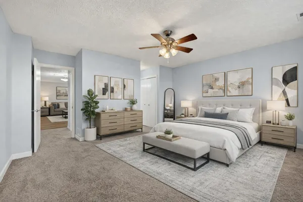 a bedroom with a large bed and a chandelier