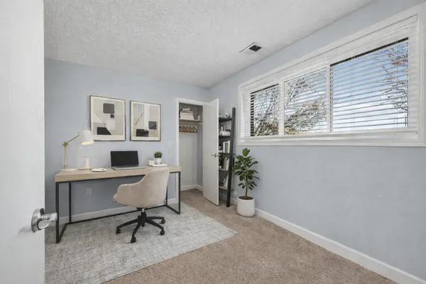 a view of a workspace with furniture and a window
