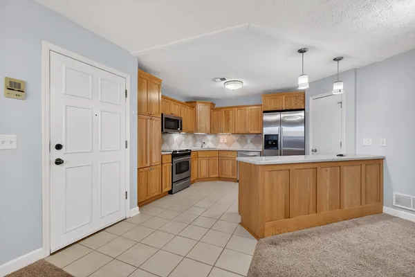 a kitchen with stainless steel appliances granite countertop a refrigerator and a sink