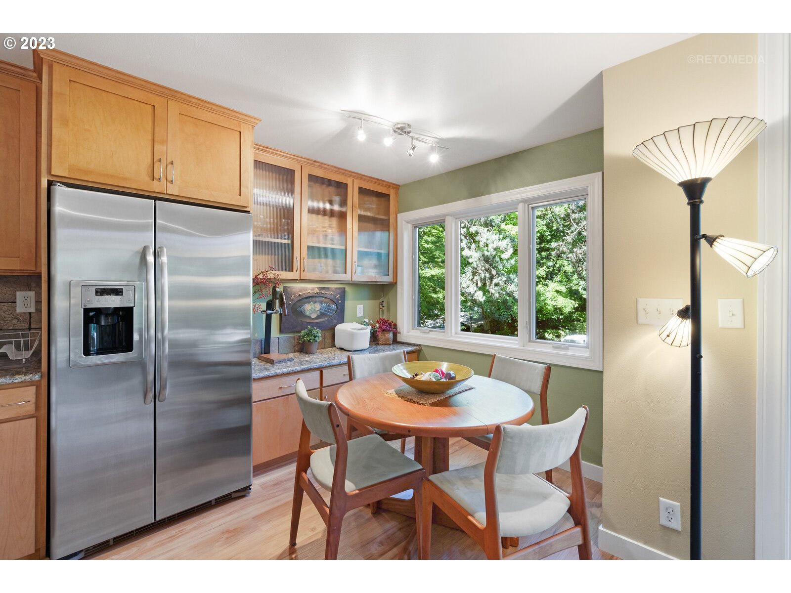 2021 Southwest Main Street, Unit 32 Portland, OR 97205 - Photo 14 of 38 a kitchen with stainless steel appliances granite countertop a table chairs and a refrigerator