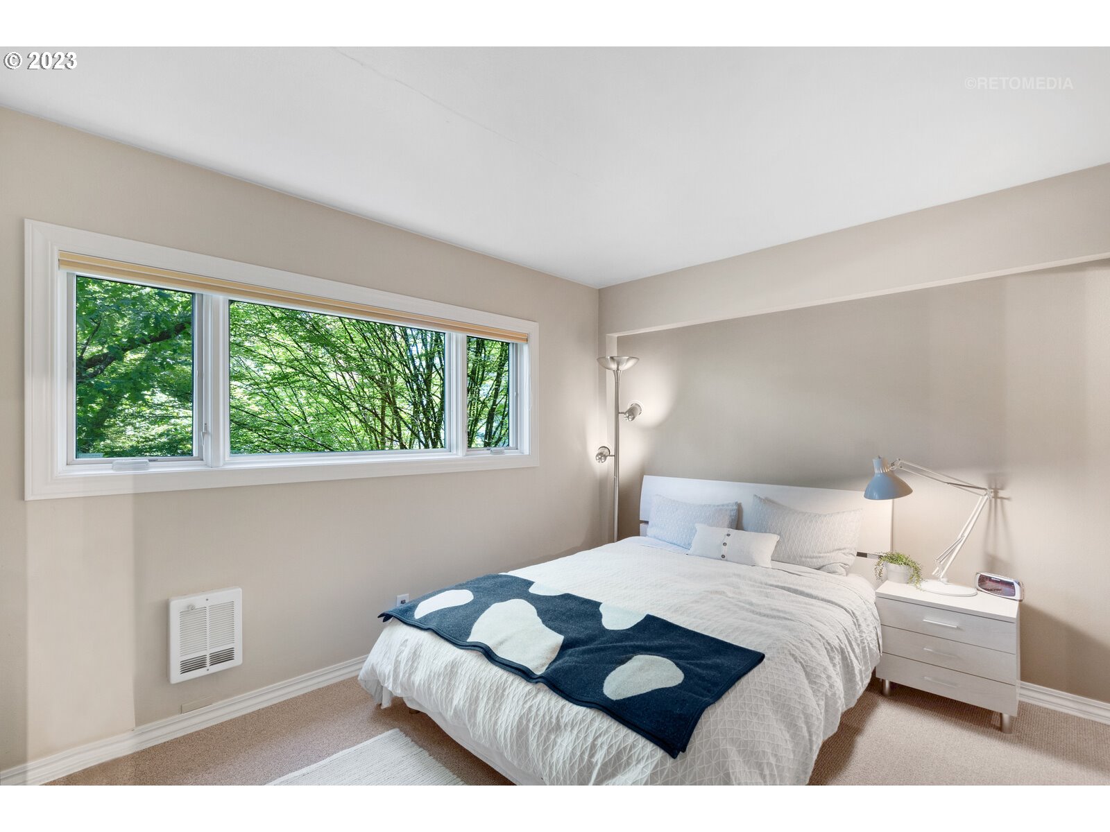 2021 Southwest Main Street, Unit 32 Portland, OR 97205 - Photo 19 of 38 a bedroom with a bed window and a lamp