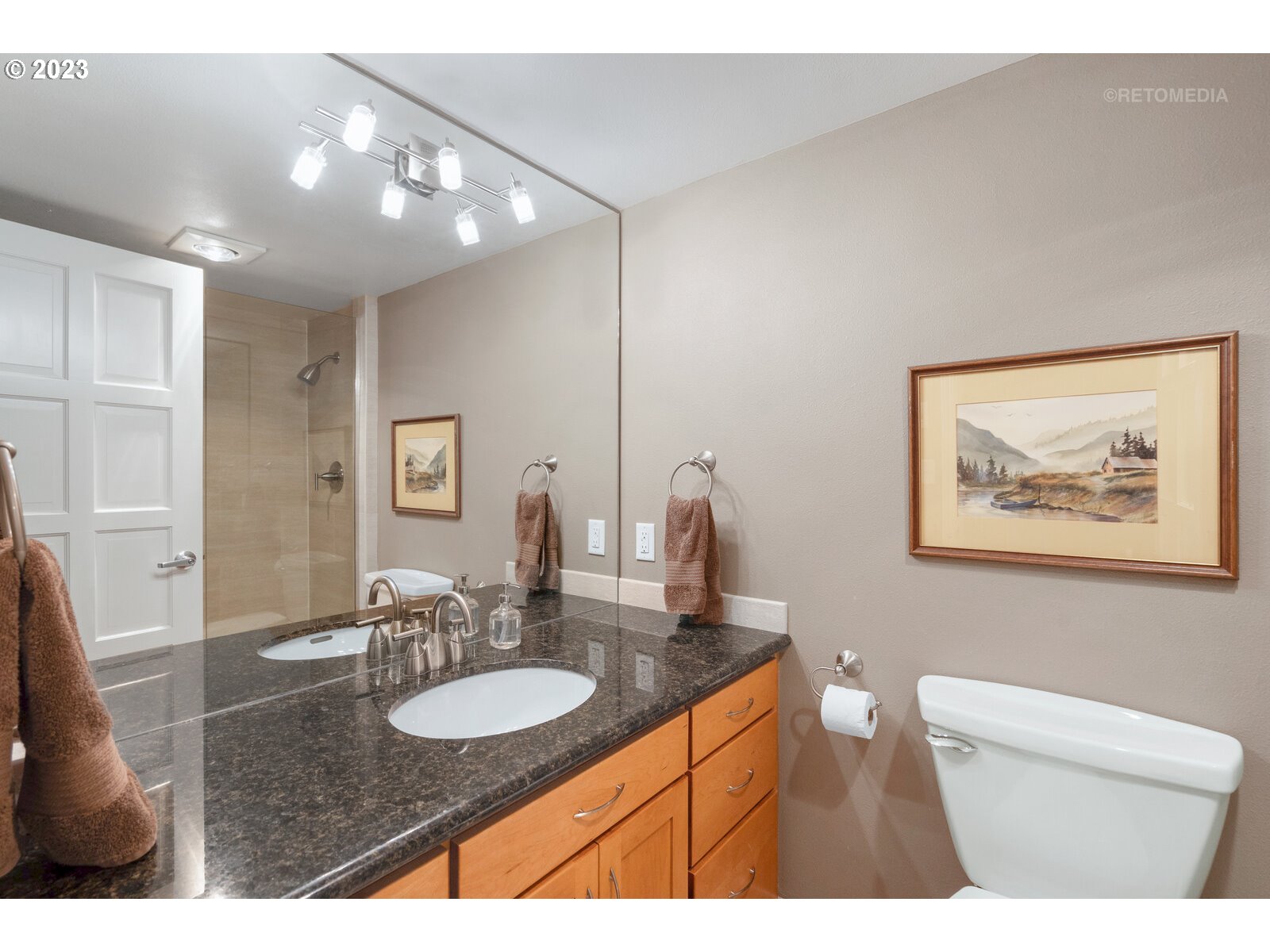 2021 Southwest Main Street, Unit 32 Portland, OR 97205 - Photo 23 of 38 a bathroom with a granite countertop sink a large mirror and a toilet