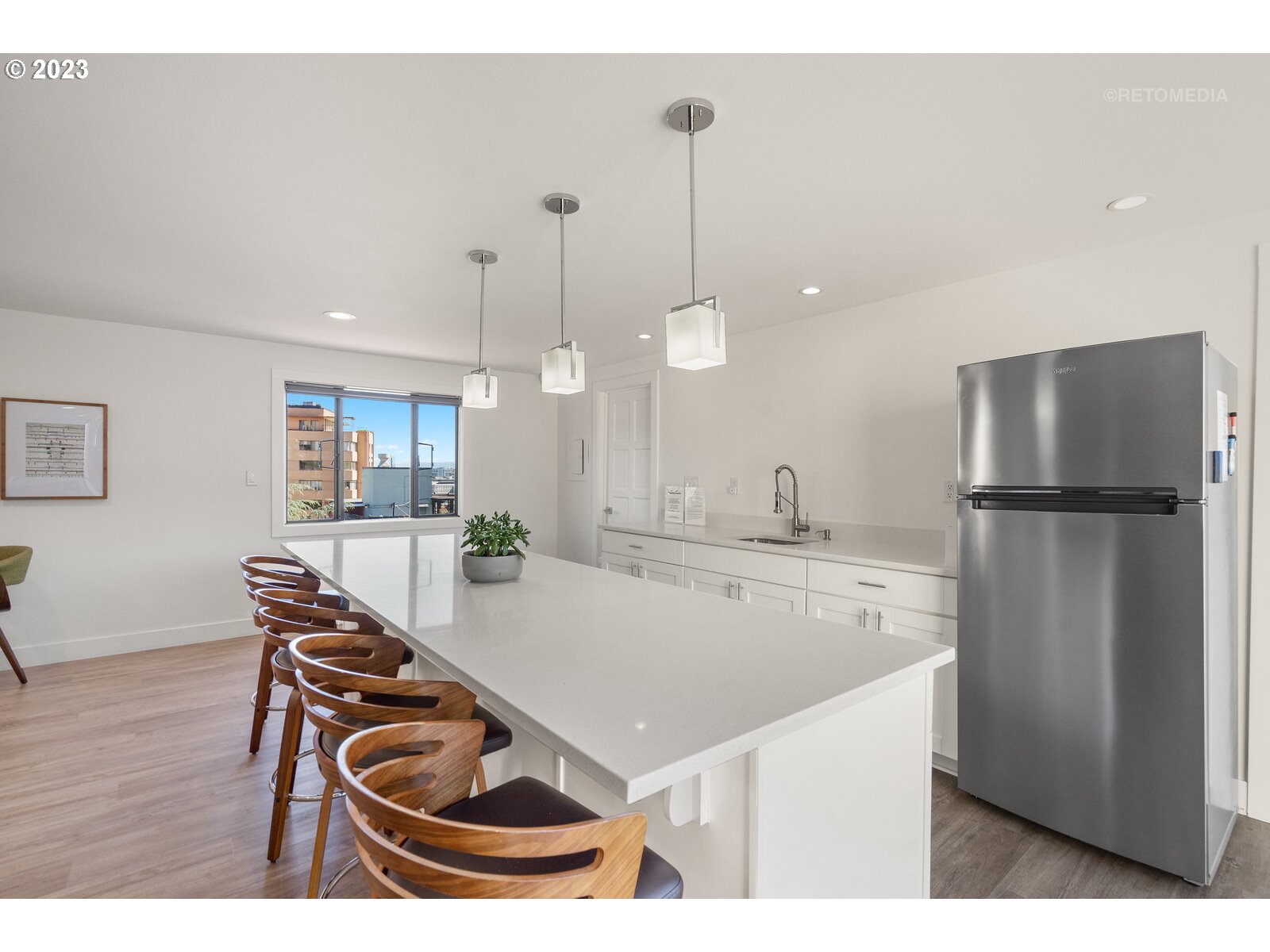 2021 Southwest Main Street, Unit 32 Portland, OR 97205 - Photo 28 of 38 a kitchen with stainless steel appliances granite countertop a refrigerator a sink a stove and a wooden floors