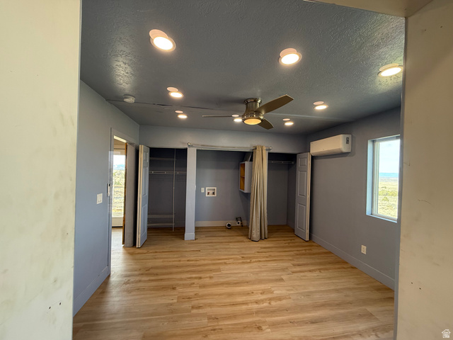 14183 High Mesa Loop Duchesne, UT 84021 - Photo 34 of 56 Unfurnished bedroom featuring multiple closets, recessed lighting, a textured ceiling, light wood-style flooring, and a ceiling fan