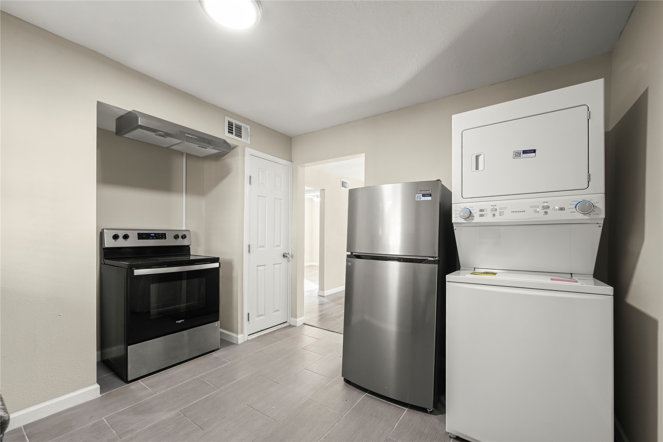 Fully equipped kitchen with stainless appliances and washer and dryer.