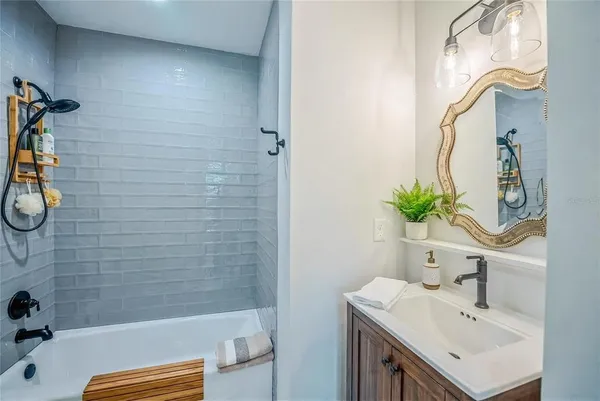 a bathroom with a sink a bathtub and a mirror