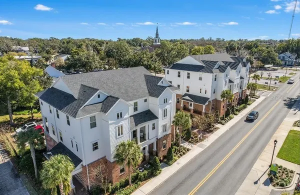a view of a house with a big yard and potted plants