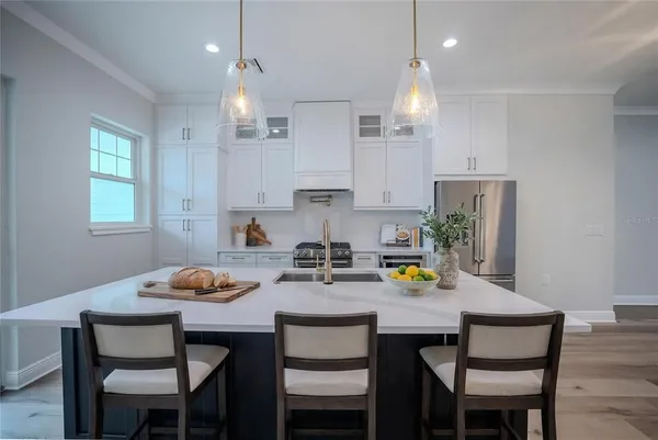 a kitchen with a dining table chairs and refrigerator