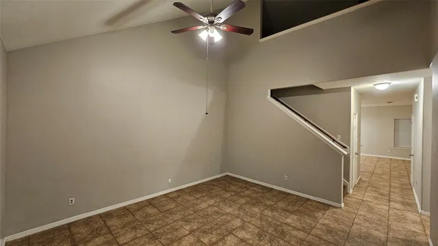 an empty room with ceiling fan and entryway