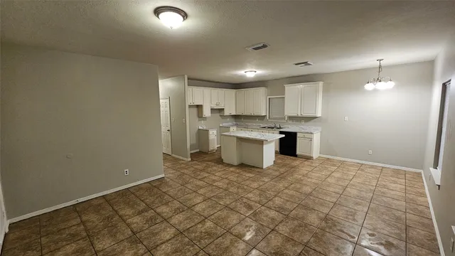 a kitchen with white cabinets and sink