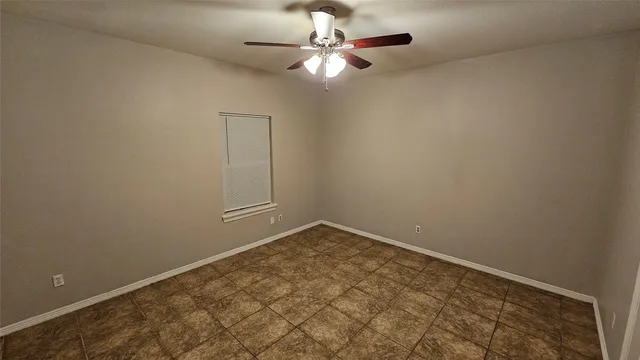 an empty room with a chandelier fan