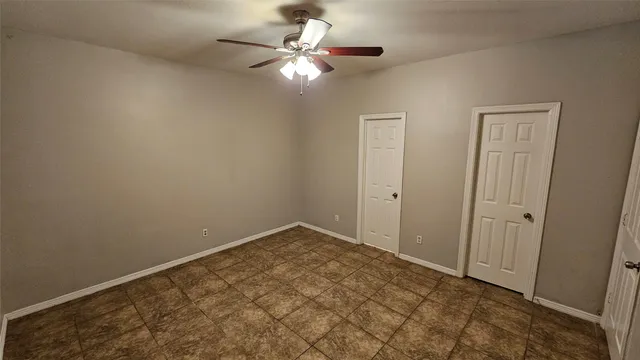 a view of kitchen and empty room with wooden floor