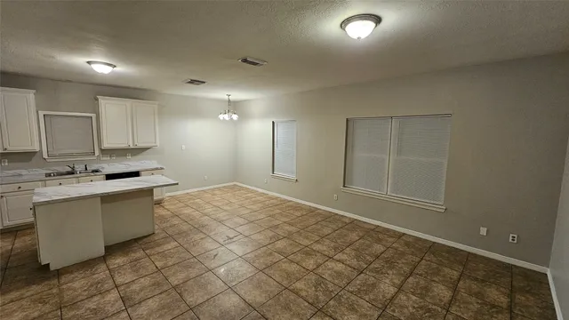 a kitchen with a sink a refrigerator and cabinets