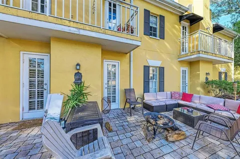 a view of a patio with couches table and chairs and potted plants