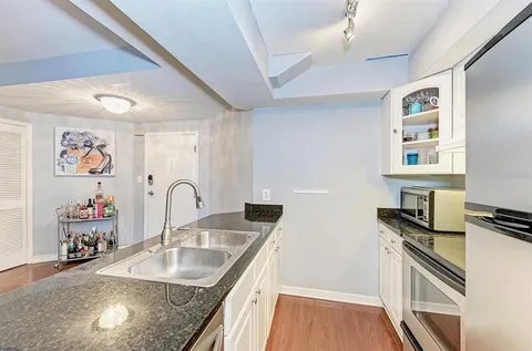 a kitchen with granite countertop a sink stove and cabinets