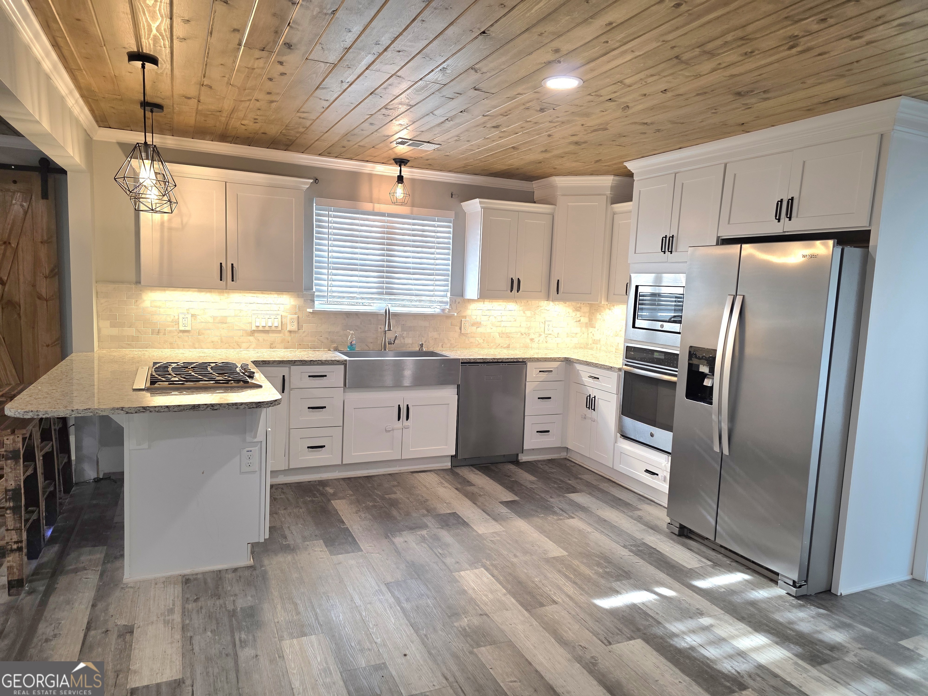 391 Price Street Statham, GA 30666 - Photo 5 of 41 a kitchen with stainless steel appliances granite countertop a refrigerator a sink dishwasher a stove and white countertops with wooden floor
