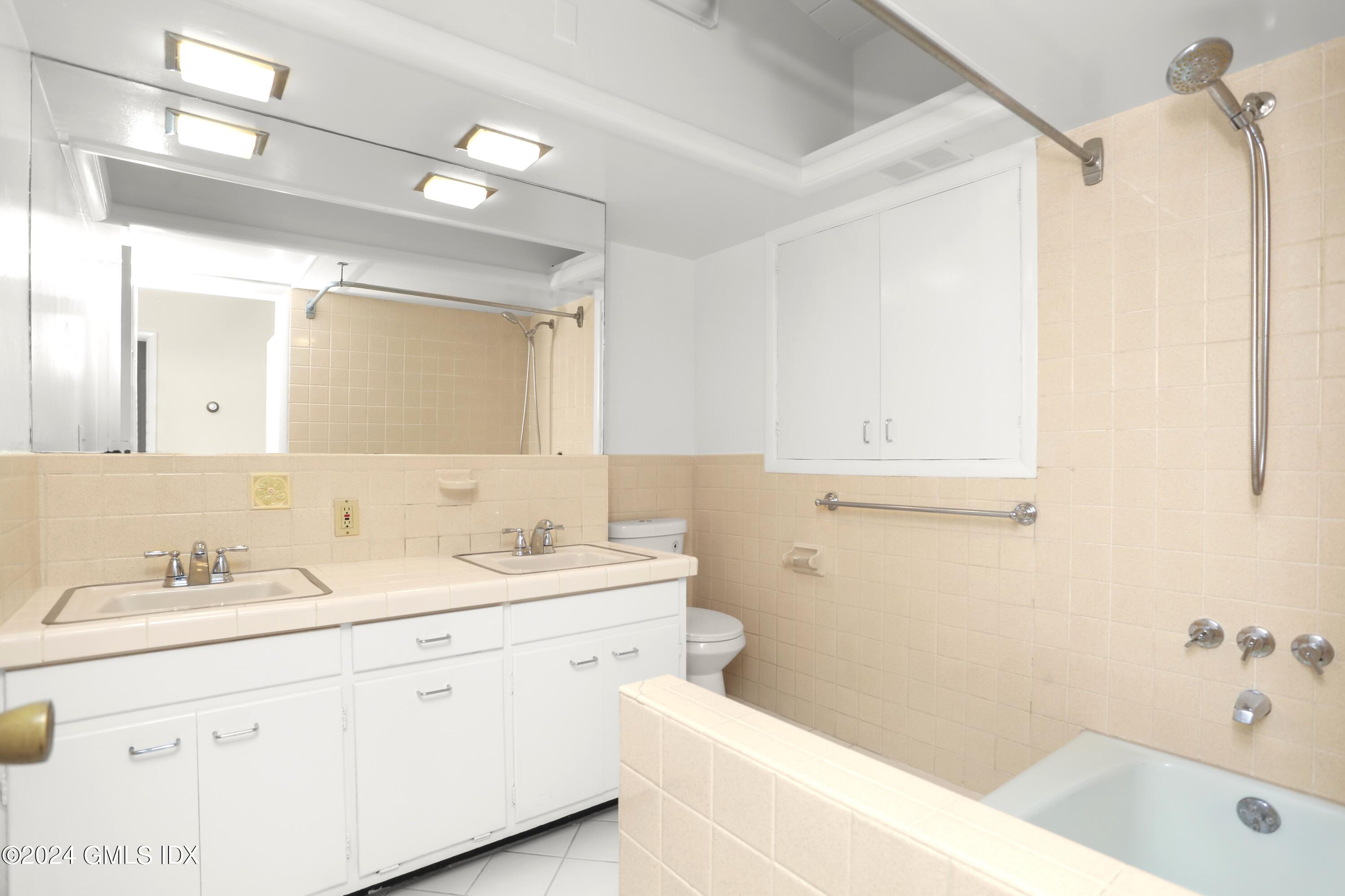 66 Arch Street Riverside, CT 06878 - Photo 17 of 30 a bathroom with a tub a sink and mirror