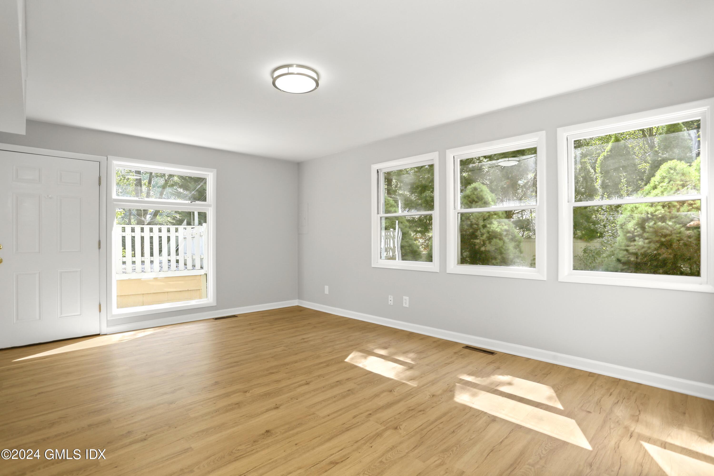 66 Arch Street Riverside, CT 06878 - Photo 18 of 30 a view of an empty room with wooden floor and a window