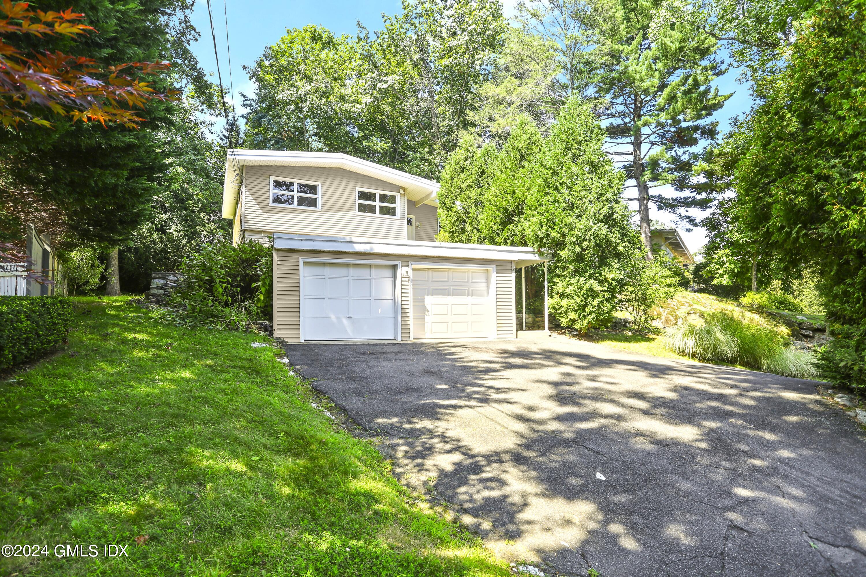 66 Arch Street Riverside, CT 06878 - Photo 22 of 30 a view of a house with a yard and garage