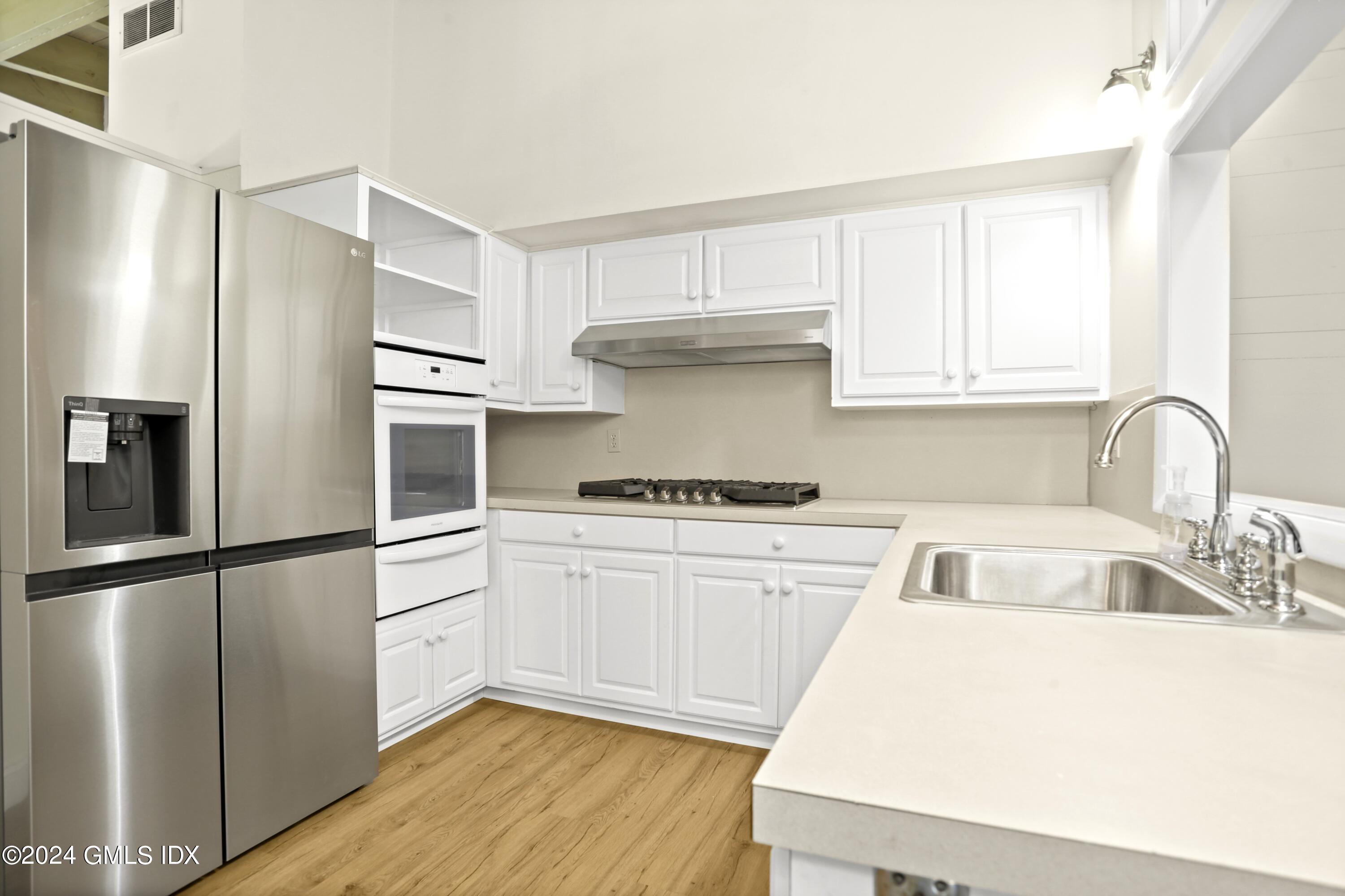 66 Arch Street Riverside, CT 06878 - Photo 7 of 30 a kitchen with a refrigerator sink and cabinets