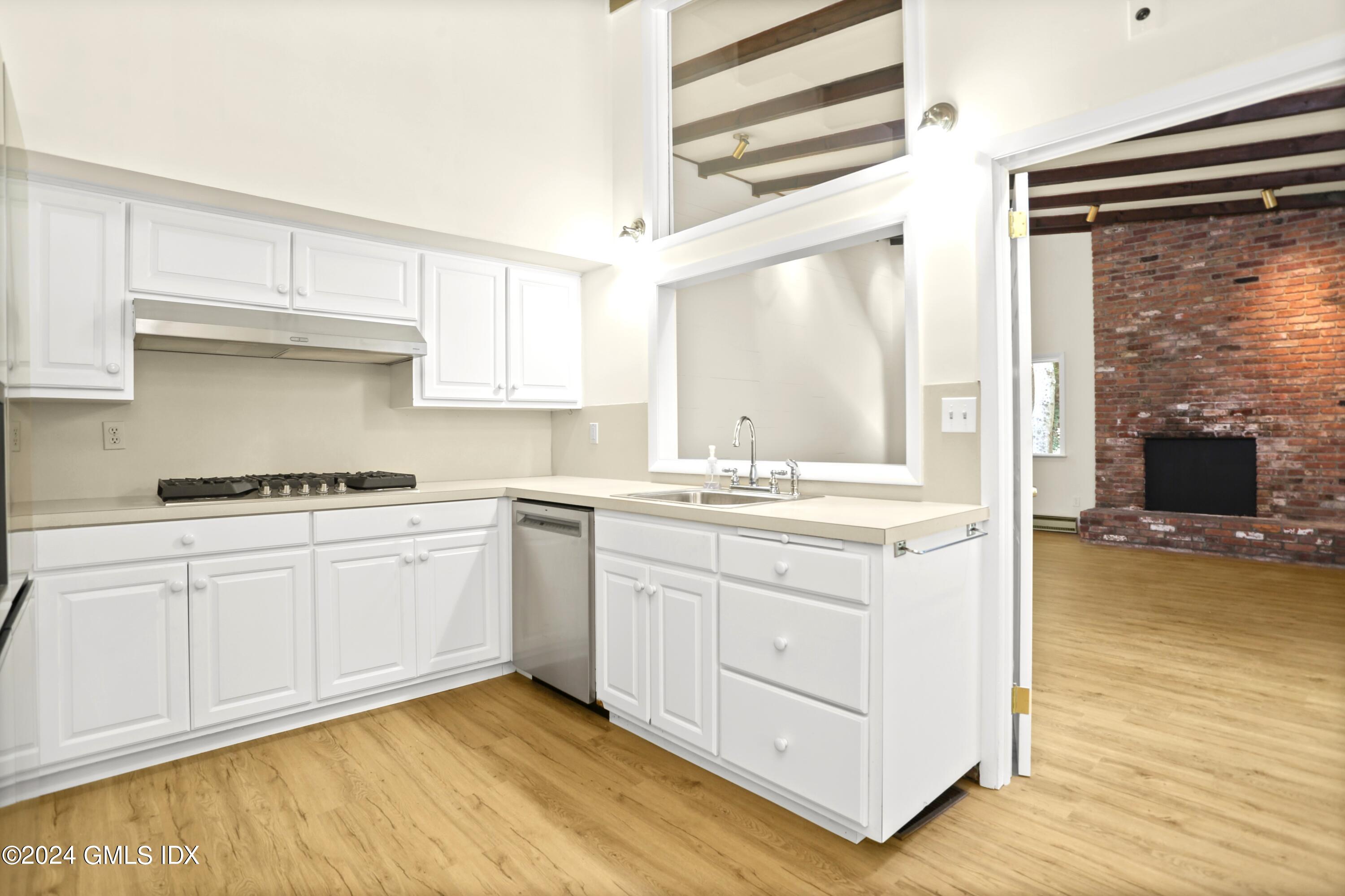 66 Arch Street Riverside, CT 06878 - Photo 9 of 30 a kitchen with granite countertop white cabinets and white appliances