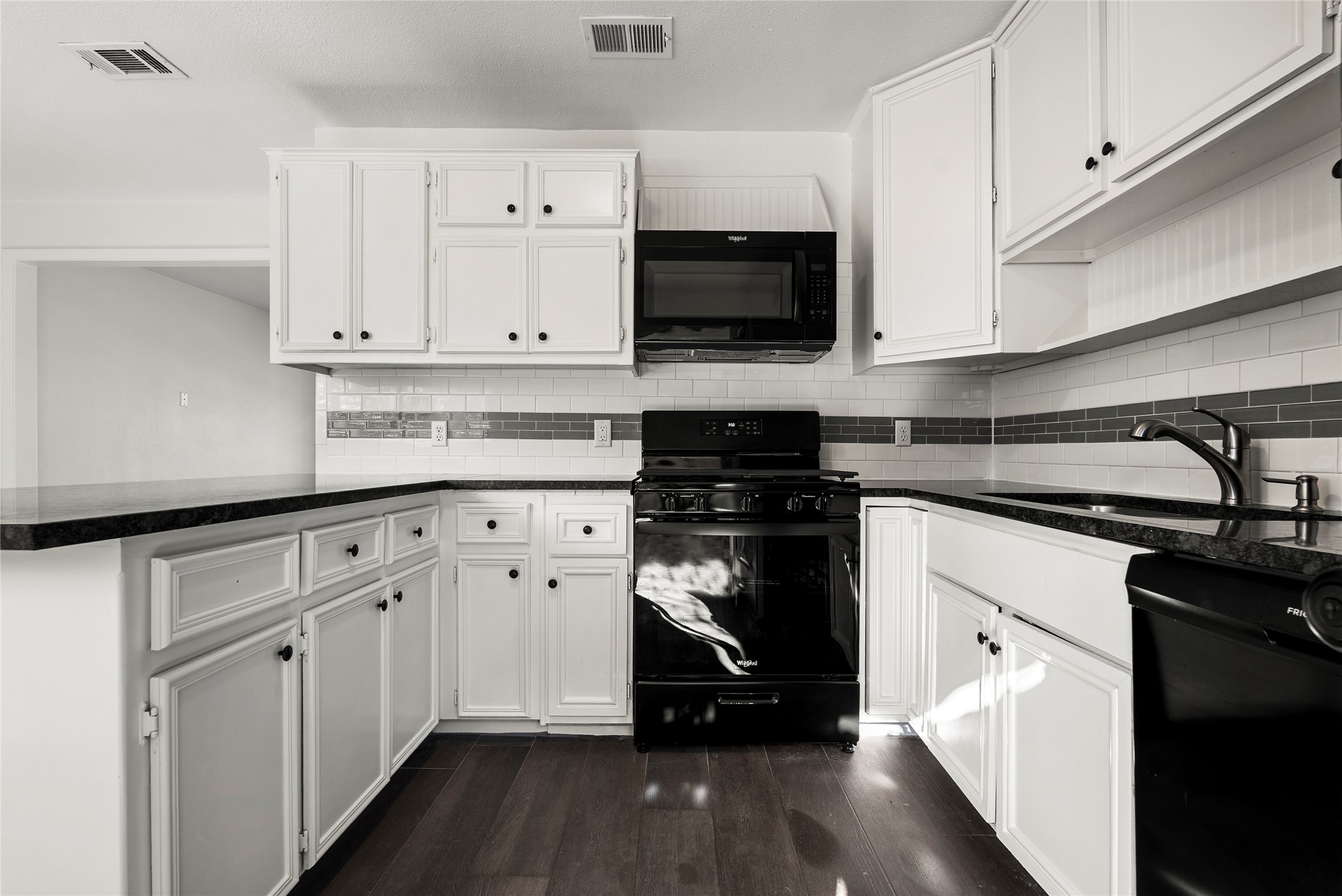 616 Mogonye Lane Elgin, TX 78621 - Photo 7 of 26 Kitchen featuring white cabinets, freestanding refrigerator, backsplash, and dark stone countertops