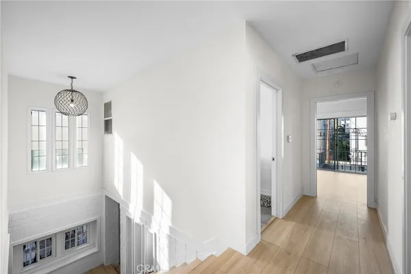 a view of an empty room with wooden floor and closet