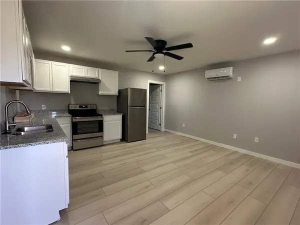 a kitchen with stainless steel appliances granite countertop a sink a stove and a refrigerator