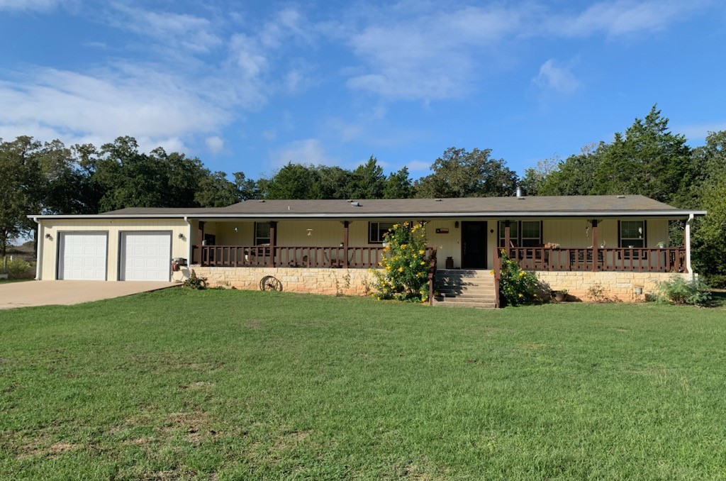 a view of a house with a yard and a porch