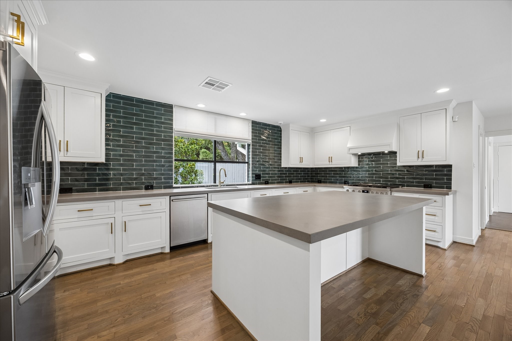 5698 Bayou Glen Road Houston, TX 77056 - Photo 8 of 30 Quartz countertops and a generous center island with seating create a space designed for both everyday living and entertaining.