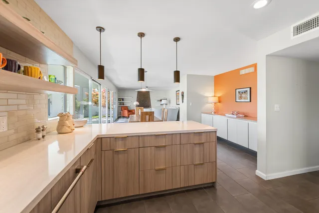 a kitchen with stainless steel appliances kitchen island granite countertop a sink a stove and a wooden floors