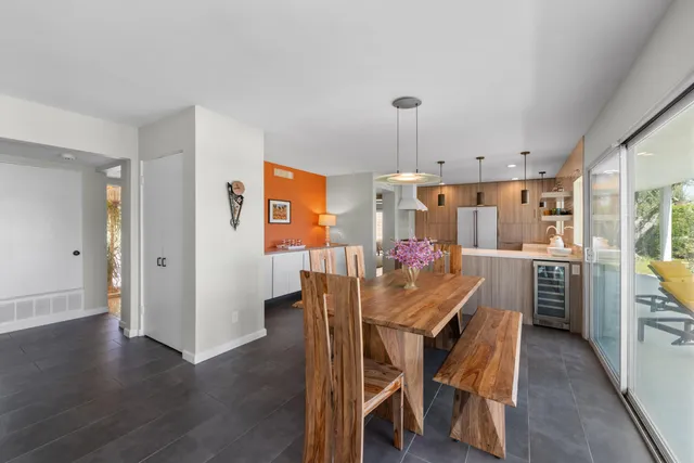 a view of a dining room and livingroom with furniture wooden floor a chandelier