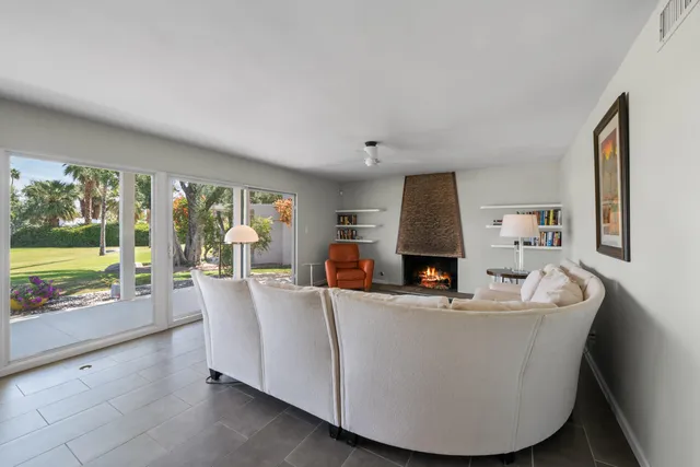 a living room with fireplace furniture and a large window