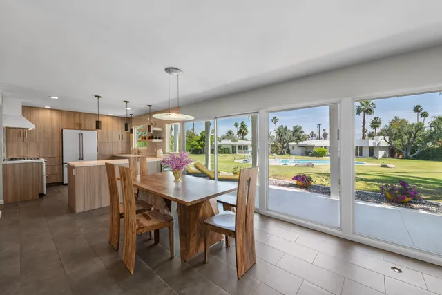 a view of a dining room and livingroom with furniture large window and garden view