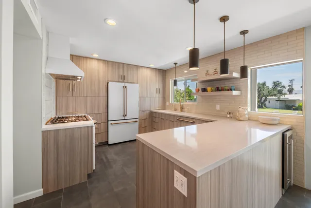 a kitchen with kitchen island a counter top space a sink stainless steel appliances and cabinets