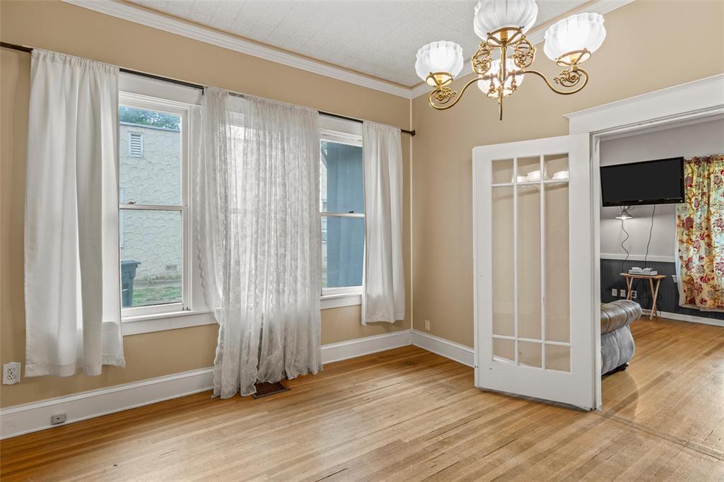 2717 Colcord Avenue Waco, TX 76707 - Photo 16 of 34 an empty room with wooden floor chandelier and windows
