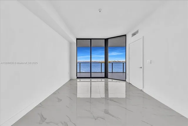 an empty room with a bathroom and mirror