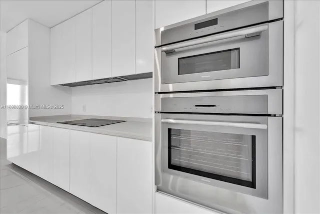 a kitchen with granite countertop white cabinets stainless steel appliances and counter space