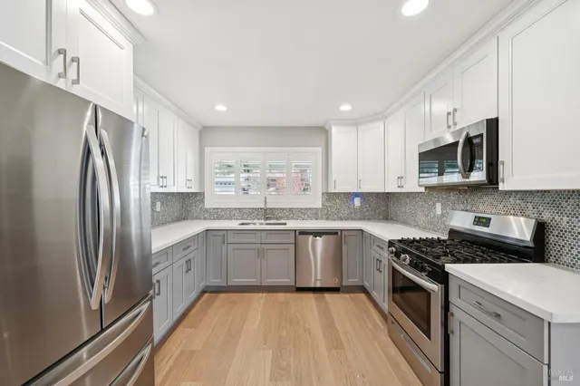 a kitchen with stainless steel appliances granite countertop a refrigerator sink and stove