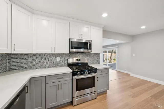 a kitchen with white cabinets and black appliances