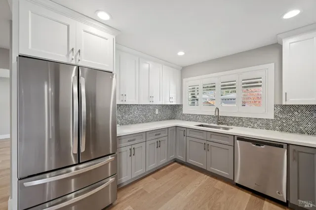 a kitchen with stainless steel appliances granite countertop a refrigerator sink and cabinets