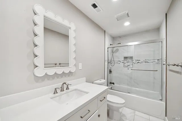 a bathroom with a shower a toilet and a glass door