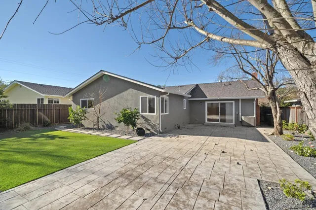 a house that has a big yard plants and large trees