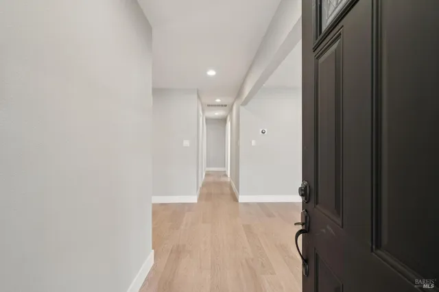 a view of a hallway with wooden floor