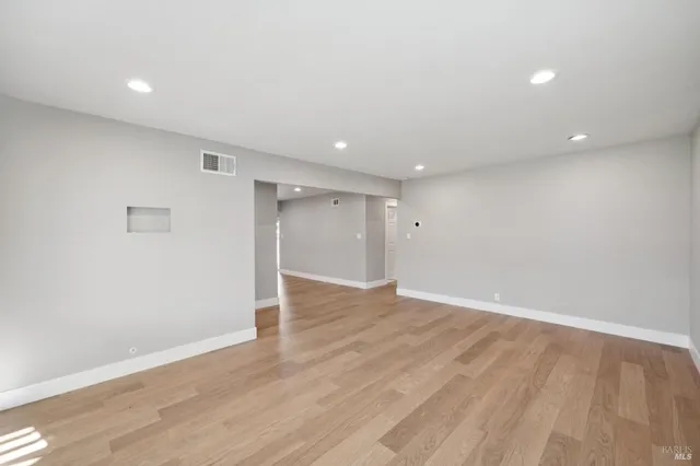 a view of an empty room with wooden floor