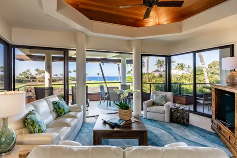a living room with furniture tv and large windows